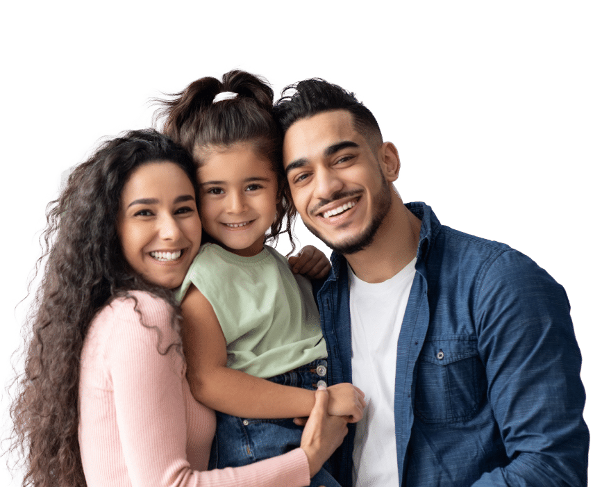 A smiling family with a woman, man, and young girl in casual outfits, closely hugging